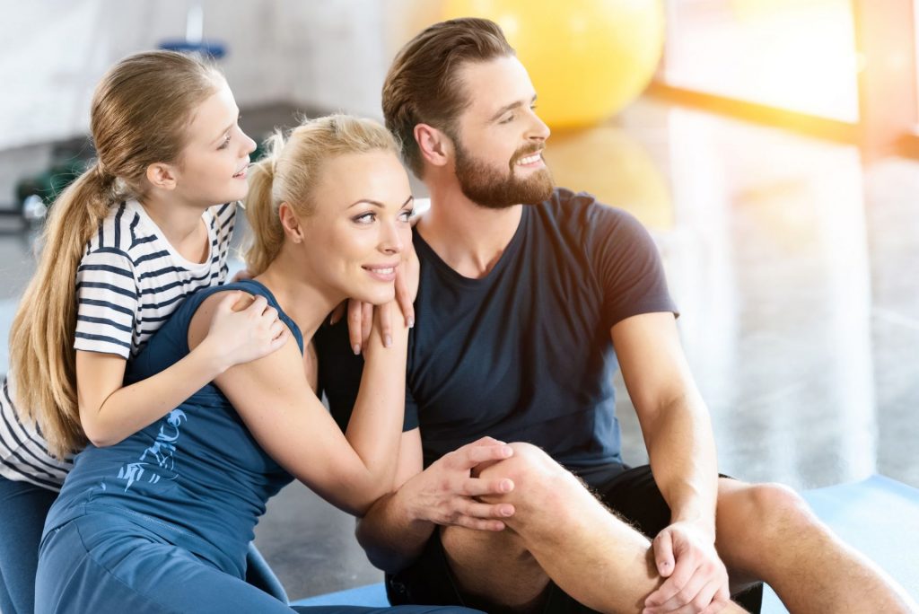 Portrait of happy family sitting at gym