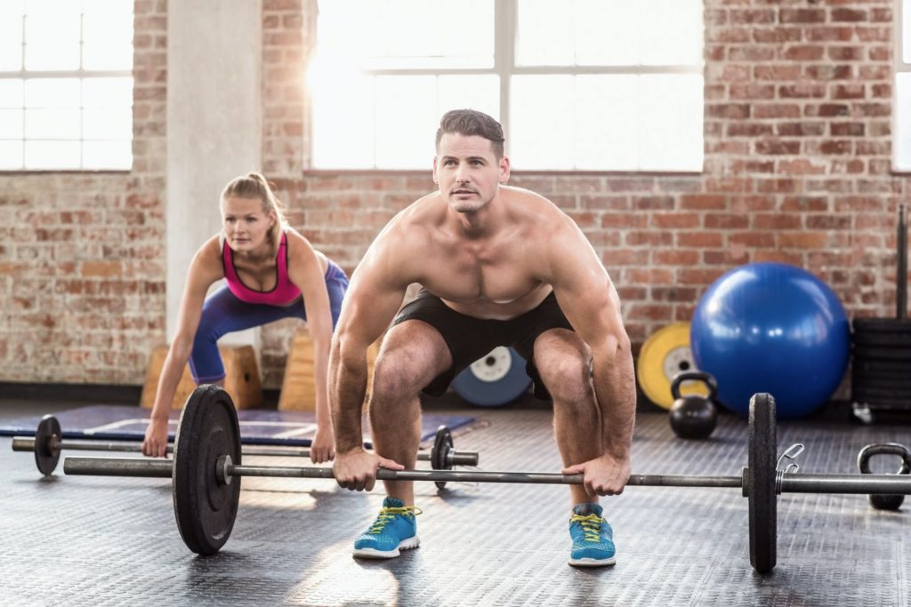 Two fit people working out in crossfit gym